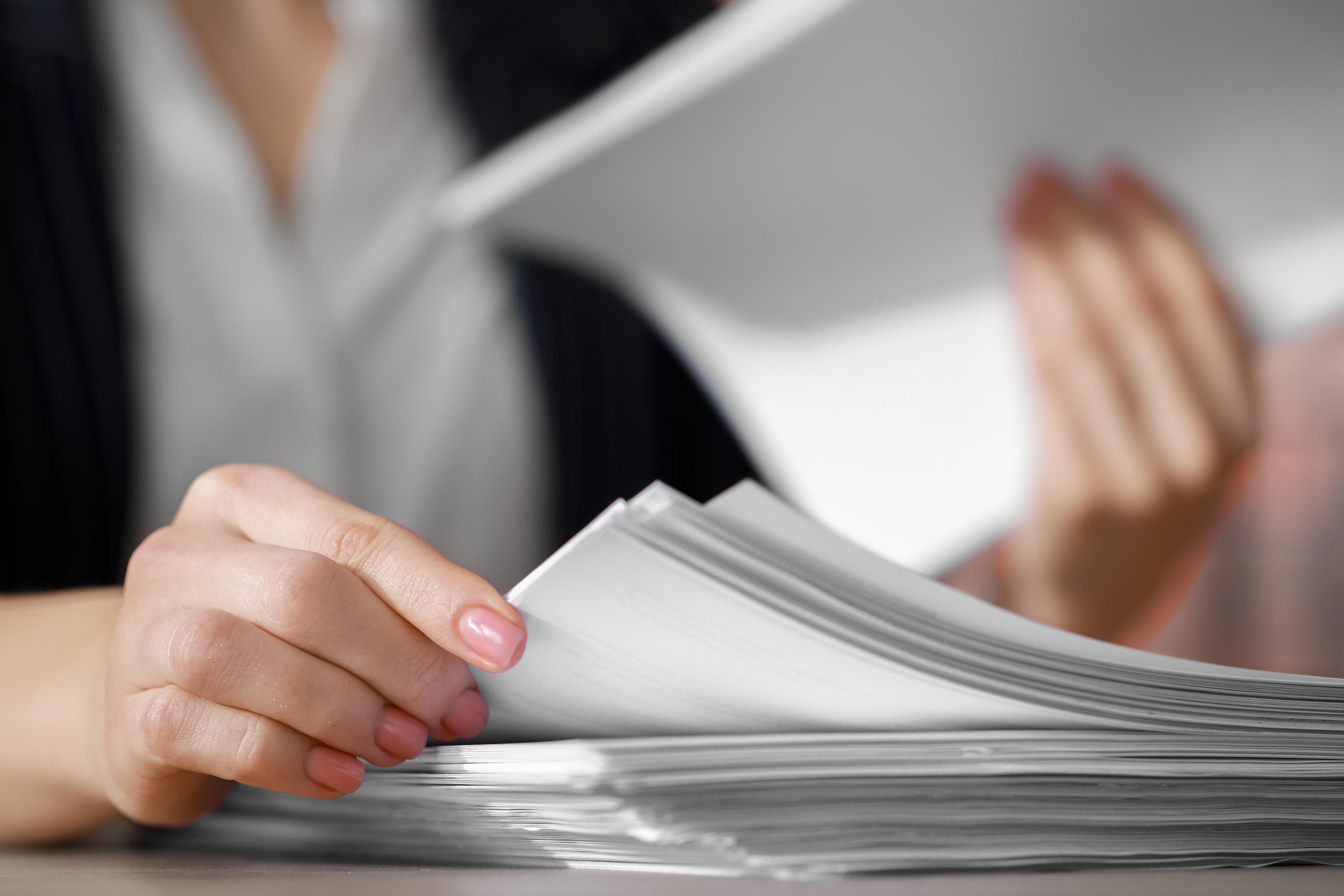 Reviewer paging through a thick multi-provider medical record by hand